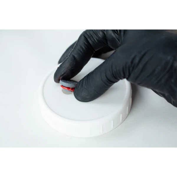 This picture shows high temperature RTV Silicon being applied on an injection port of a Liquid culture Jar's lid to seal any gaps.
