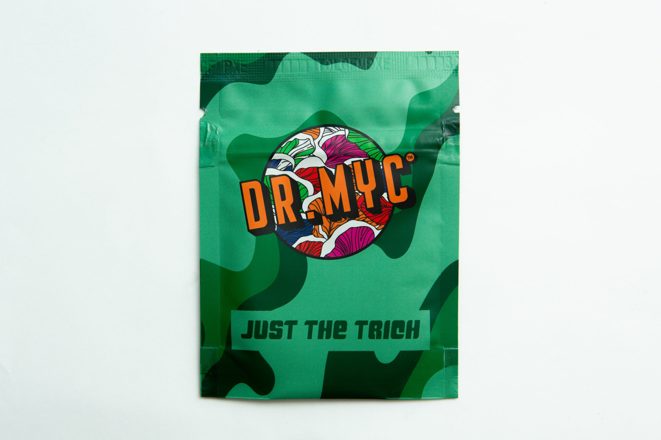 The DRMyc Adaptive Liquid Culture Premix comes in a green packet with a colorful mushroom design and "JUST THE TRICH" text—perfect for preparing liquid culture easily.