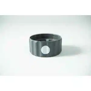 The Plant Cell Biocoupler™ Neck is a black bottle cap with a white circular sticker on its side, resting on a white surface and featuring a defined neck for added structure.