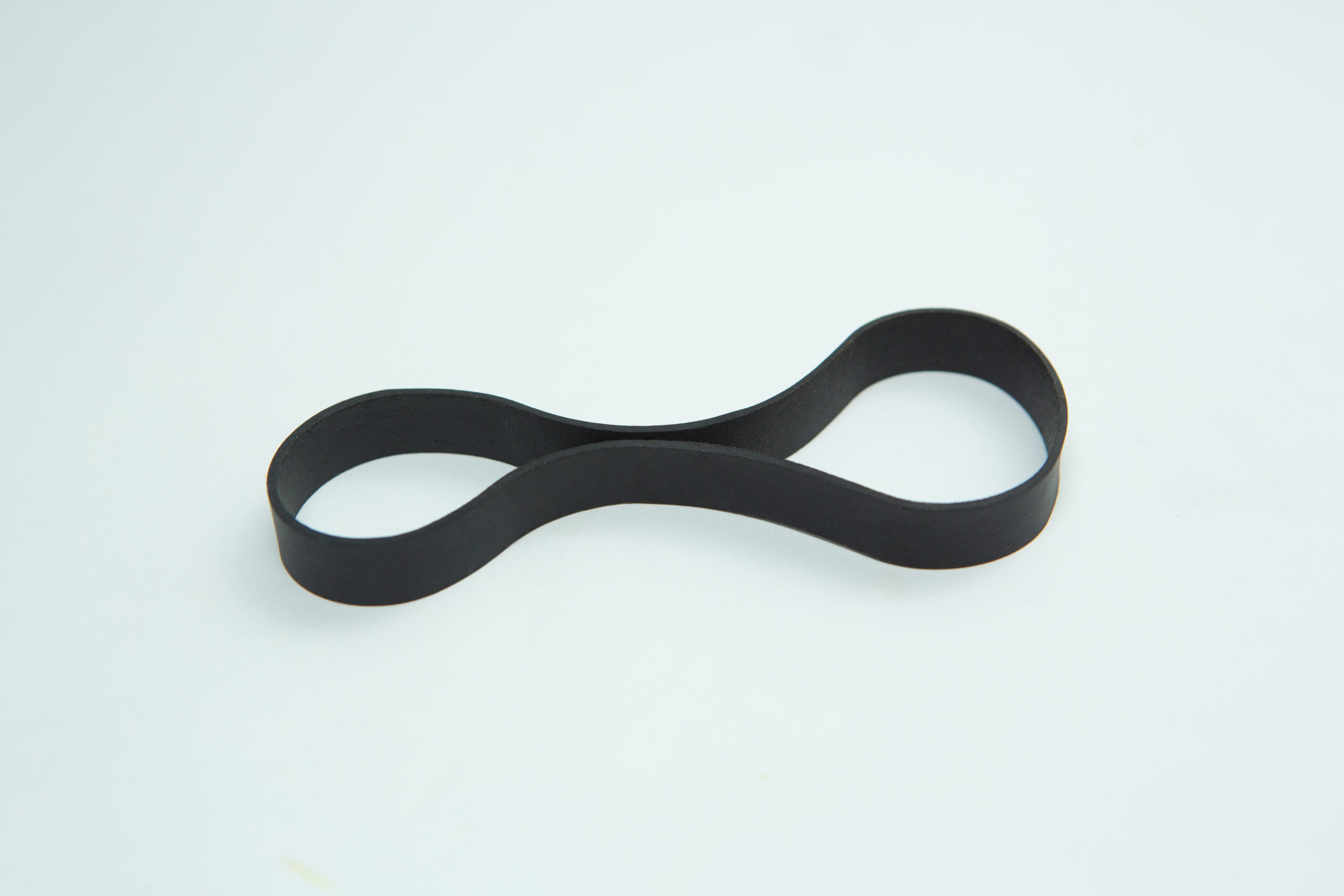 A reusable black Fruiting Rubber Band for Mushroom Growing (10pcs) is twisted into a figure eight on a white background. Perfect for mushroom cultivation.
