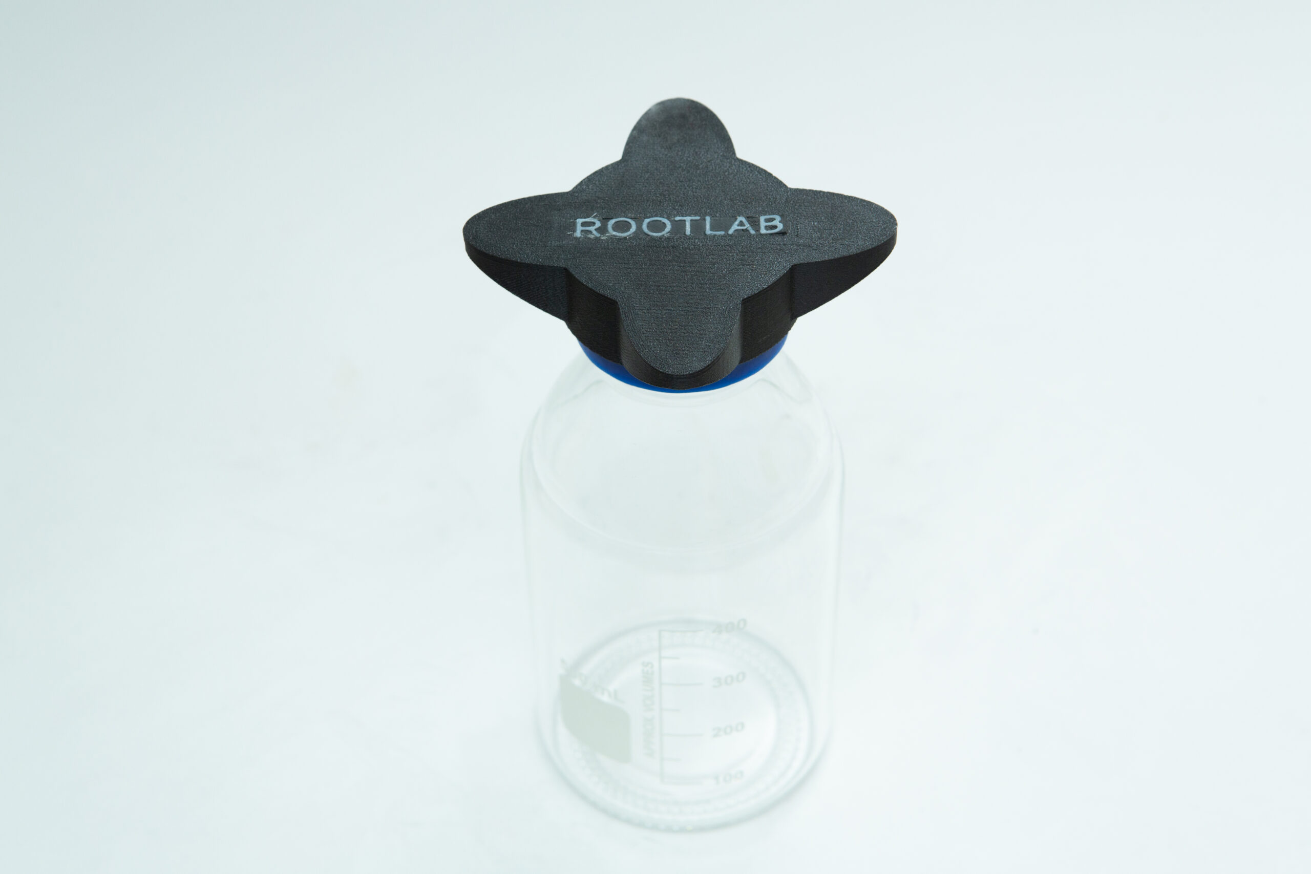 Clear glass bottle with a black cap labeled ROOTLAB on a white background.