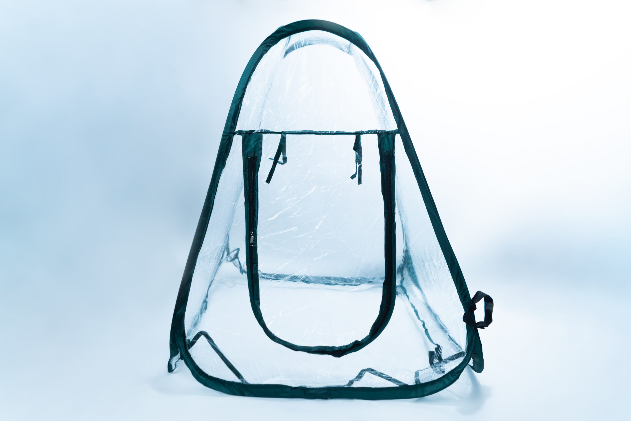 A clear plastic pop-up tent with a zippered front door, set against a light background.
