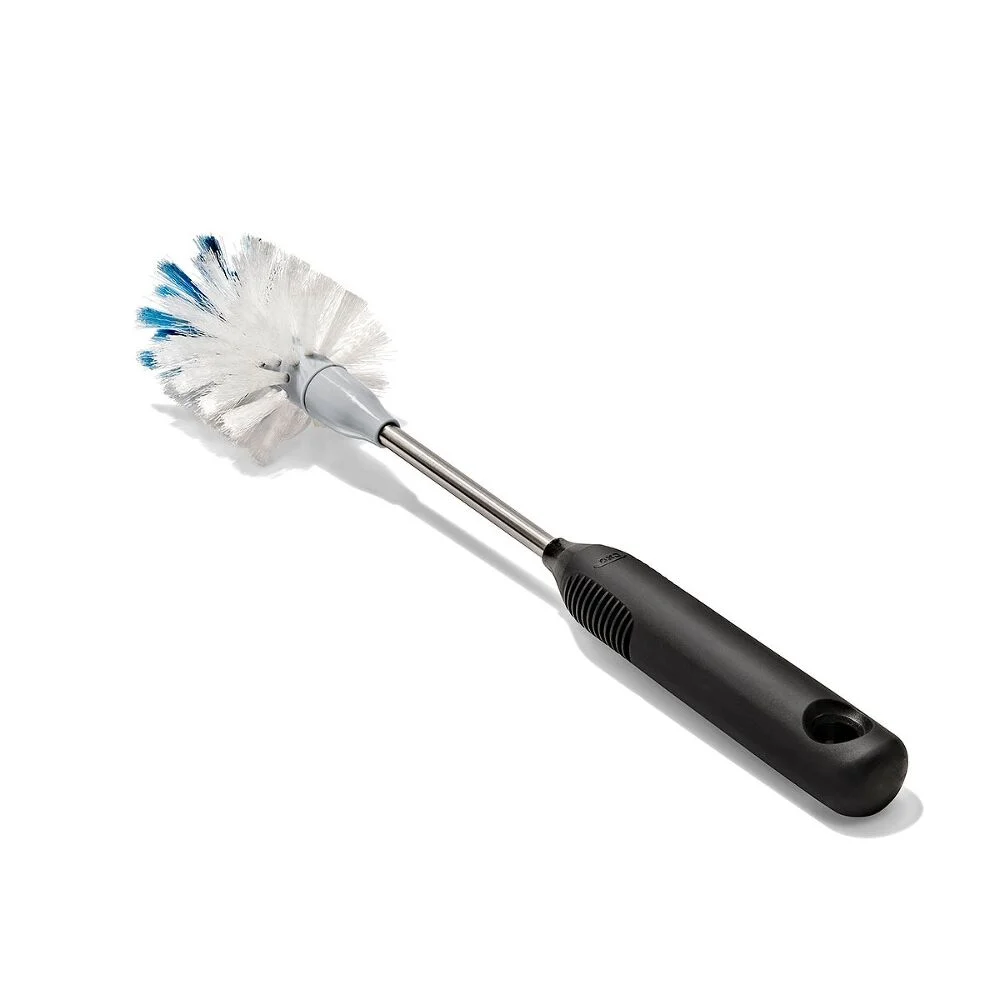 A bottle brush with a black handle and white bristles, some bristles tipped with blue, on a white background.